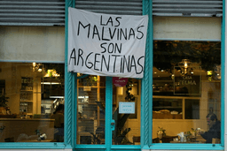 A man sits at a restaurant displaying a banner reading "The Malvinas are Argentine," referring to the Falkland Islands, also known as Malvinas, in Buenos Aires, Argentina, Monday, July 27, 2026. (AP Photo/Natacha Pisarenko)